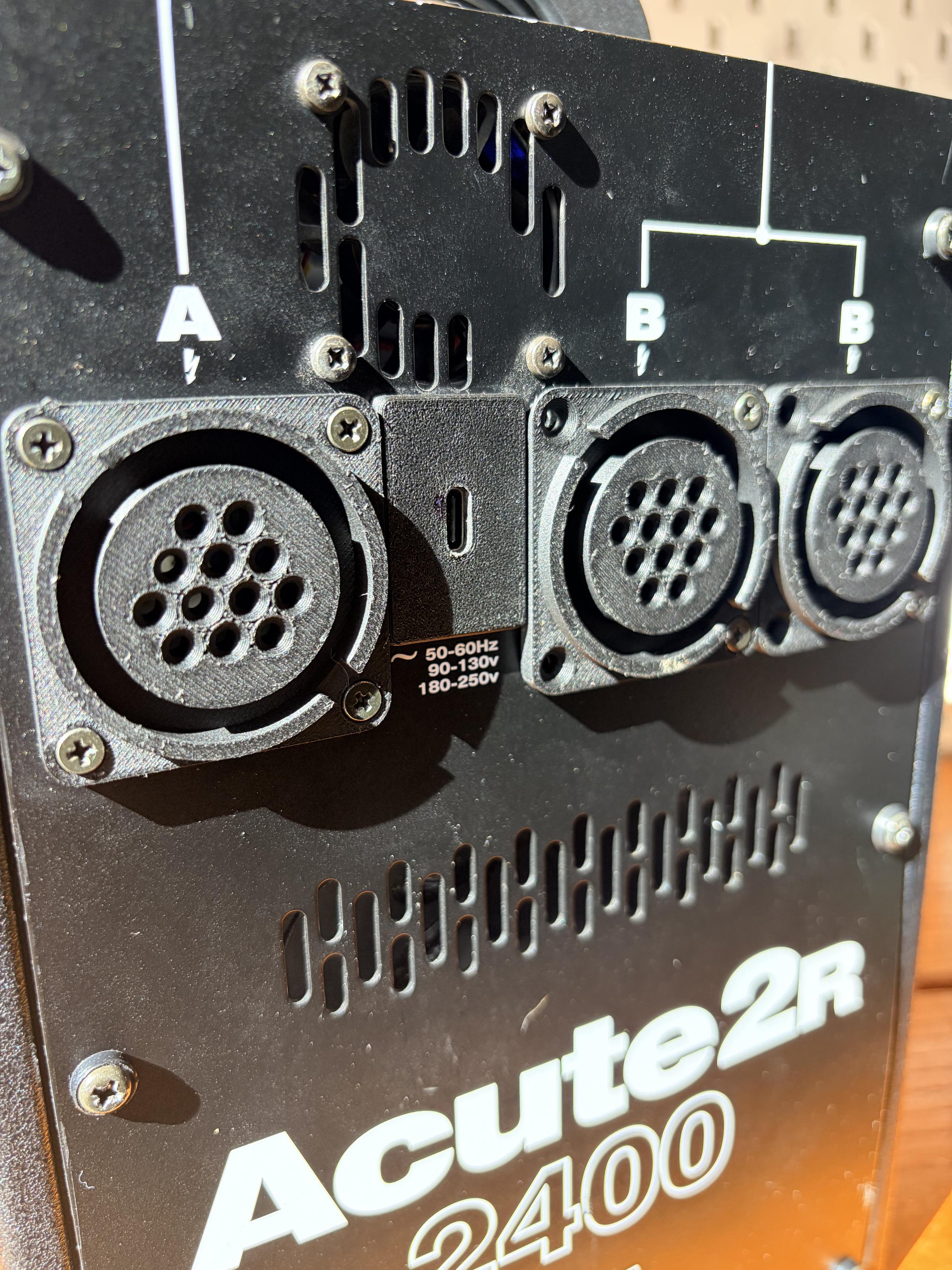 The front panel of an old Profoto Acute pack. Normally this is where the connectors for three strobe heads and mains power go. Now the head connectors have been replaced with 3D printed versions and the power with a USB-C port