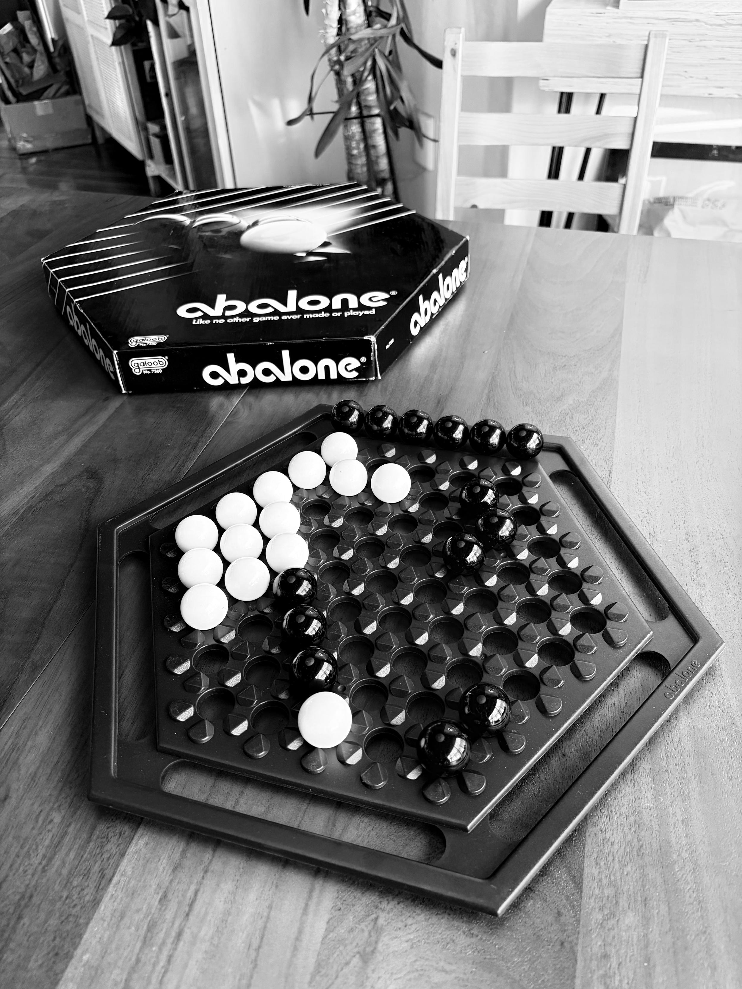 The game Abalone, which is made of a hexagonal board with marbles. The goal is to push columns of marbles off the edge of the board